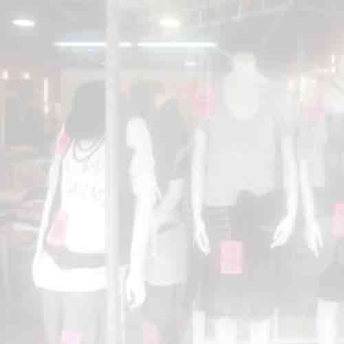 Blurred view of mannequins in women's clothing displayed in a Cheung Sha Wan Road shop window